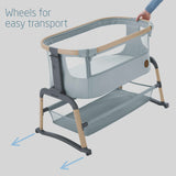 Portable baby crib with wheels for easy transport on a light gray background
